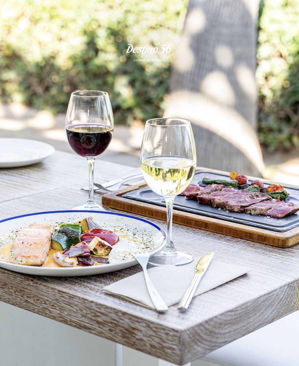 Mesa en Destino 56 con vino y aperitivos junto a la playa